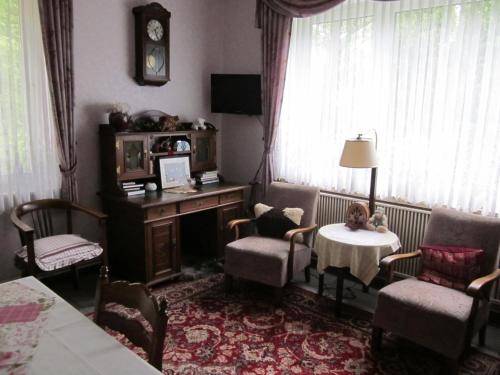 维岑多夫Haus Annegret的客厅配有桌椅和时钟