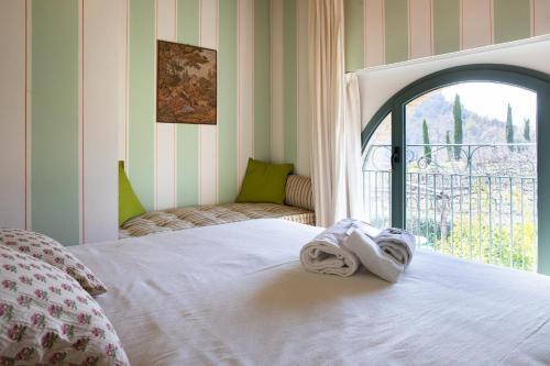TorrianaTenuta Saiano Resort的窗户间里一张带毛巾的床