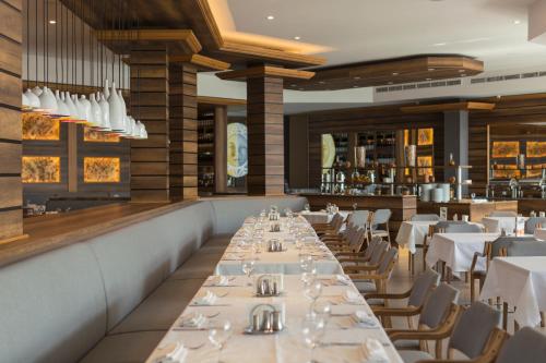 古多里古柯里马可波罗酒店的一间设有白色桌椅的用餐室