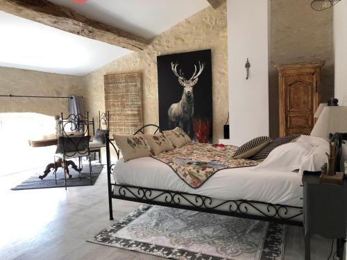 RauzanL'Ilot Vignes的卧室配有一张床铺,墙上挂着鹿的照片