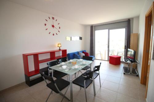艾姆布里亚布拉瓦Apart-rent Apartment Puig Rom 0149的一间带桌椅和时钟的用餐室