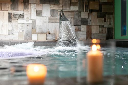 费拉迪普利米罗伊索拉贝拉健康酒店的游泳池里的喷泉,有两根蜡烛