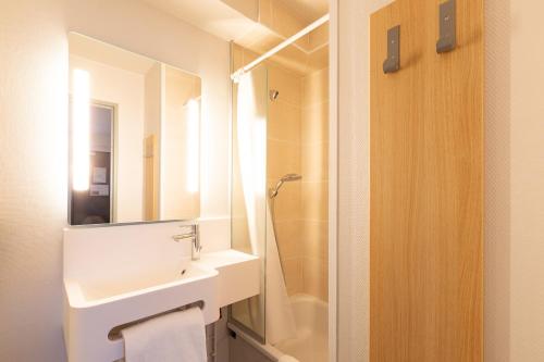 ChangéB&B HOTEL Laval Changé的一间带水槽、镜子和淋浴的浴室
