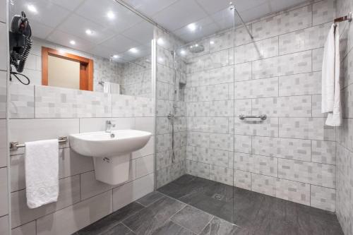 大加那利岛拉斯帕尔马斯和蔼酒店的白色的浴室设有水槽和淋浴。