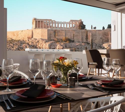 雅典卫城精选酒店的餐桌和酒杯,享有大楼的景致