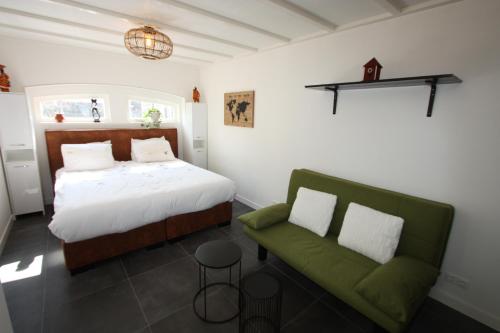 吕伐登Het prinsentuintje的一间卧室配有一张床和一张绿色沙发