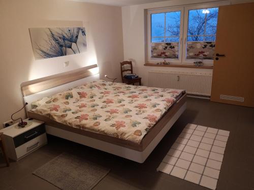施莱登Ferienwohnung Schmahl的一间卧室配有一张带花卉棉被的床