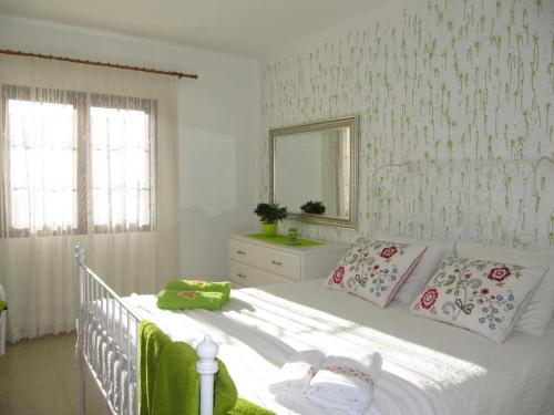 塔伊切Casa Montaña de Tahiche的卧室配有一张带镜子的白色床