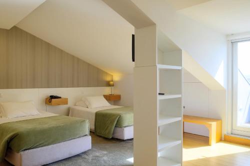 维亚纳堡拉兰热拉酒店的一间卧室设有两张床和书架
