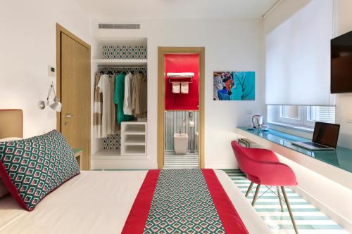 索伦托Casa Dominova de Luxe的一间卧室配有一张床、一张桌子和一把红色椅子