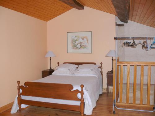 圣艾米隆Les Oiseaux的一间卧室配有带白色床单和枕头的床。