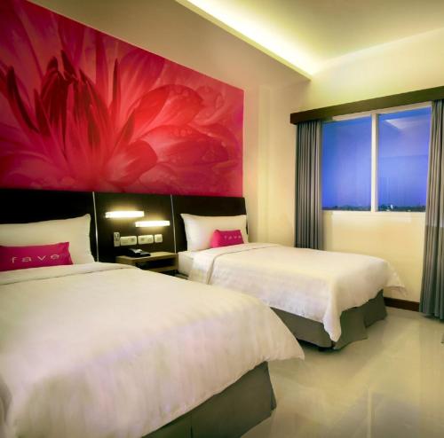 日惹库苏曼尼卡拉大街酒店的墙上画画的房间里设有两张床