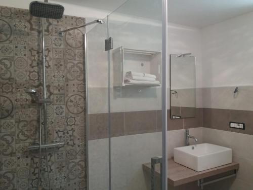 圣斯泰法诺贝尔博Il mestiere di vivere -casa vacanze-的一间带水槽和玻璃淋浴的浴室