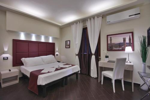 锡尼亚欧罗之家舒适公寓的一间卧室配有一张床、一张桌子和一张书桌