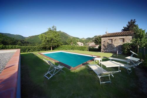 博尔戈阿莫扎诺Casa Patrizia的一个带椅子的庭院和房子的游泳池