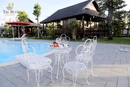 金瓯THƯ DUY Resort的游泳池前的桌椅