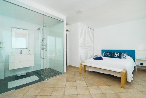 哈维亚Villa Bombon的一间卧室设有一张床和一个玻璃淋浴间