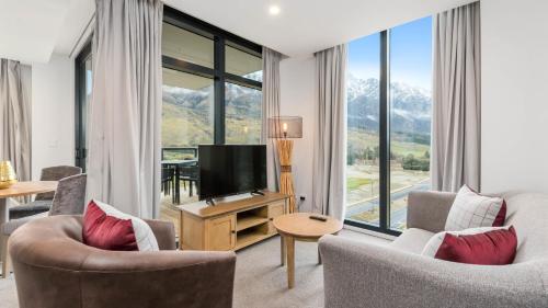 皇后镇Remarkables Garden Apartment 305的客厅配有两把椅子和电视