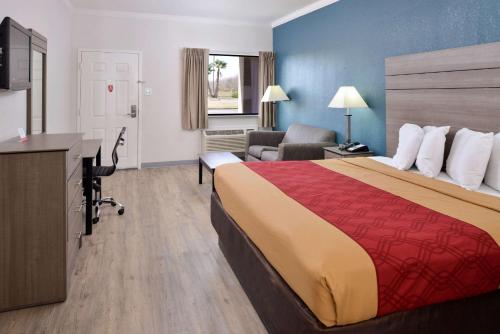 亚瑟港Econo Lodge Inn & Suites Port Arthur near Sabine Pass的酒店客房设有一张大床和一张书桌。