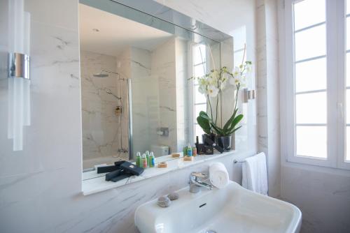 滨海博利厄Hotel Carlton的白色的浴室设有水槽和镜子