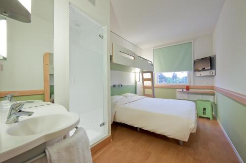 卢加诺卢加诺天堂宜必思快捷酒店的客房内的浴室设有床和水槽