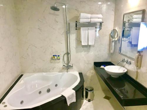 迪拜迪尔拉萨玛雅酒店的一间带大浴缸和水槽的浴室