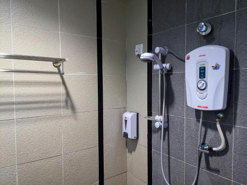 马六甲淡边中心酒店的浴室设有淋浴,墙上配有电话