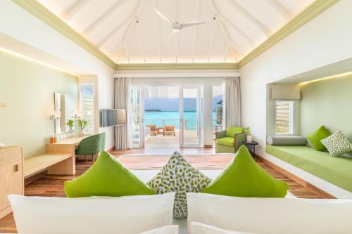 南马累环礁Sun Siyam Olhuveli的客厅配有绿色家具,享有海景。