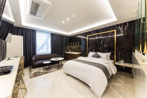 龙仁市Astro Hotel的卧室配有一张白色大床和黑色墙壁