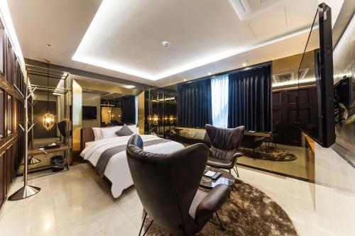 龙仁市Astro Hotel的酒店客房,配有一张床、一张桌子和椅子