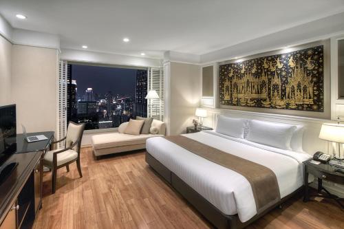 曼谷曼谷拉查丹利中心酒店的一间带大床的卧室和一间客厅
