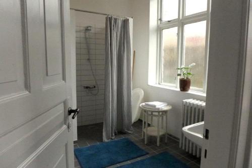 里伯To sammenhængende værelser med udgang til have的带淋浴和卫生间的浴室以及窗户。