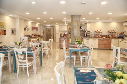 图兹拉Tuzla Garden Hotel & Spa的一间带桌椅的用餐室和一间厨房