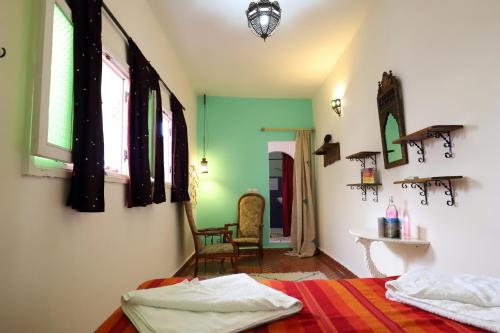 穆莱伊德里斯达尔泽霍恩酒店的卧室拥有绿色和白色的墙壁,配有一张床