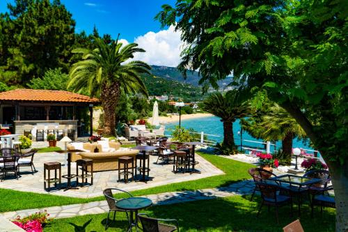 帕雷恩特西菲基昂Villa Romantica Hotel的一个带桌椅的庭院,毗邻水域