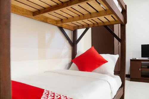 达沃市OYO 153 Espacio de Clarita Hometel的一张带红色和白色枕头的床