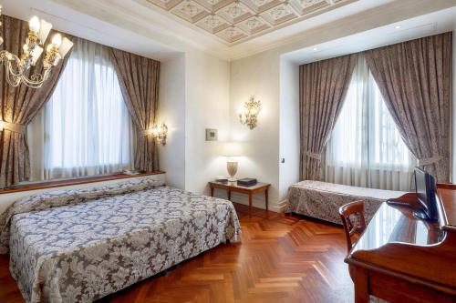 罗马阿凡缇诺酒店的一间卧室设有两张床、一张桌子和窗户。