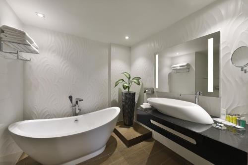 塞提夫Park Mall Hotel & Conference Center的一间带大型白色浴缸和大镜子的浴室