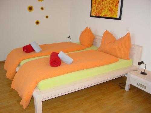 埃申茨拉本酒店的一间卧室配有两张带橙色枕头的床