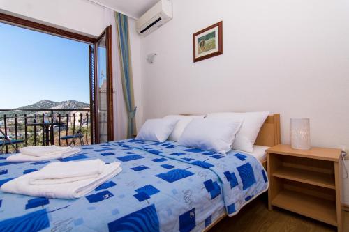 希杰弗朗吉卡Apartments Jozic的卧室配有蓝色和白色的床和阳台。