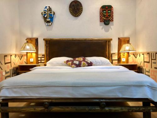 帕科坦Guest House Adriatica by Pinch的一间卧室配有一张大床,配有两盏灯和钟。