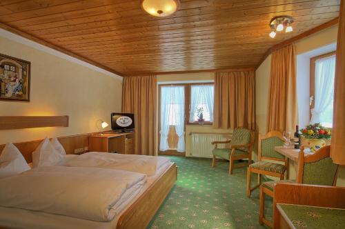 柯尼希斯湖畔舍瑙伯格马特酒店的酒店客房带一张床、一张桌子和椅子