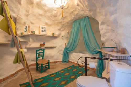 莫纳奇尔Casa Cueva Muntasal的洞穴内的浴室,配有卫生间和椅子