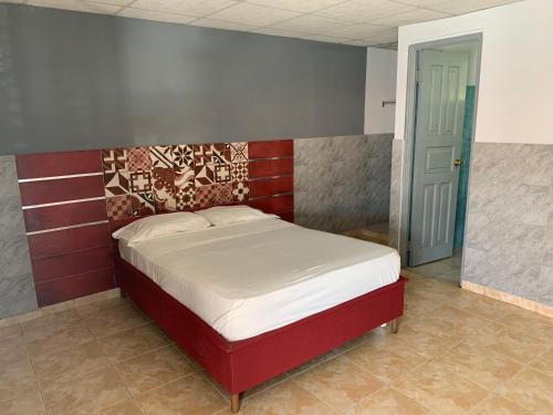 AguadulceRESIDENCIAL AGUADULCE的一间卧室配有一张红色床头板的床
