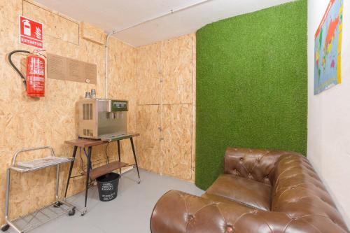 阿利坎特Tomate Rooms的配有绿色墙壁的客房内的真皮沙发