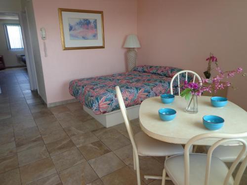 怀尔德伍德棕榈岛汽车旅馆的客房设有桌子、床和桌椅。