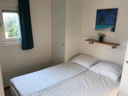 艾默伊登Blauwe Zeedistel的一间小卧室,配有床和窗户
