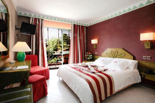 马拉喀什凯姆斯酒店的酒店客房,配有一张床和一张红色椅子