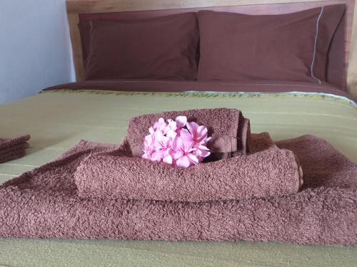Fajã da Caldeira de Santo CristoCasa da Fajã - RRAL nº 635的床上的毛巾堆,有粉红色的花