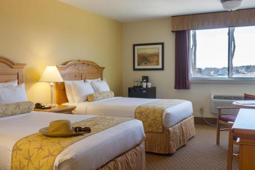西雅茅斯碧沙度假酒店的酒店客房设有两张床和窗户。